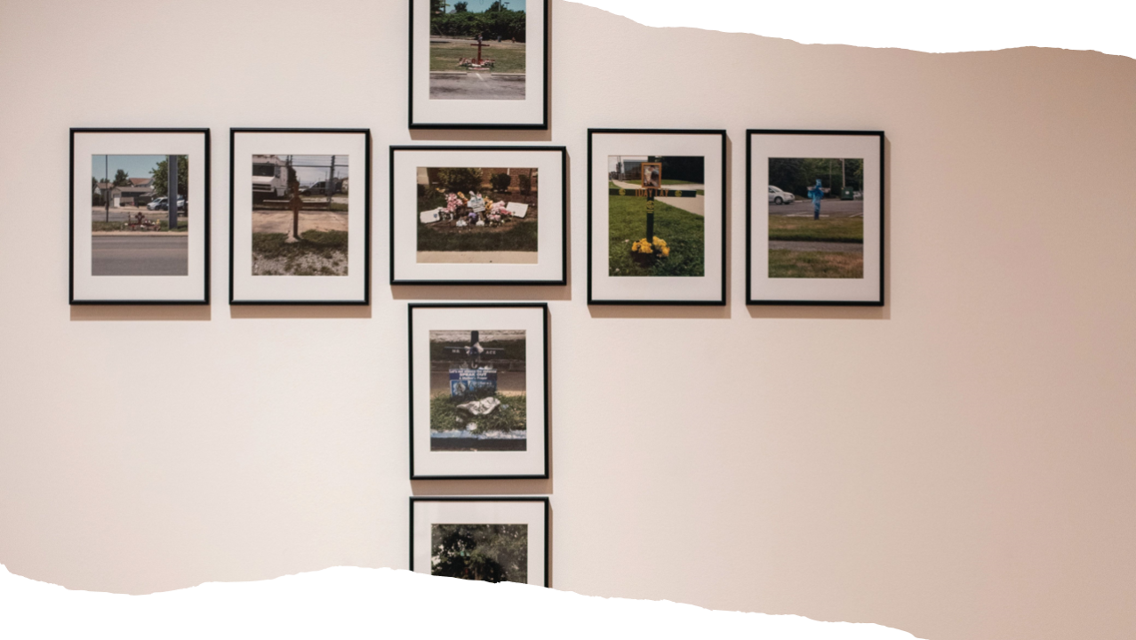 A set of framed pictures are displayed in a cross pattern on a blank wall.