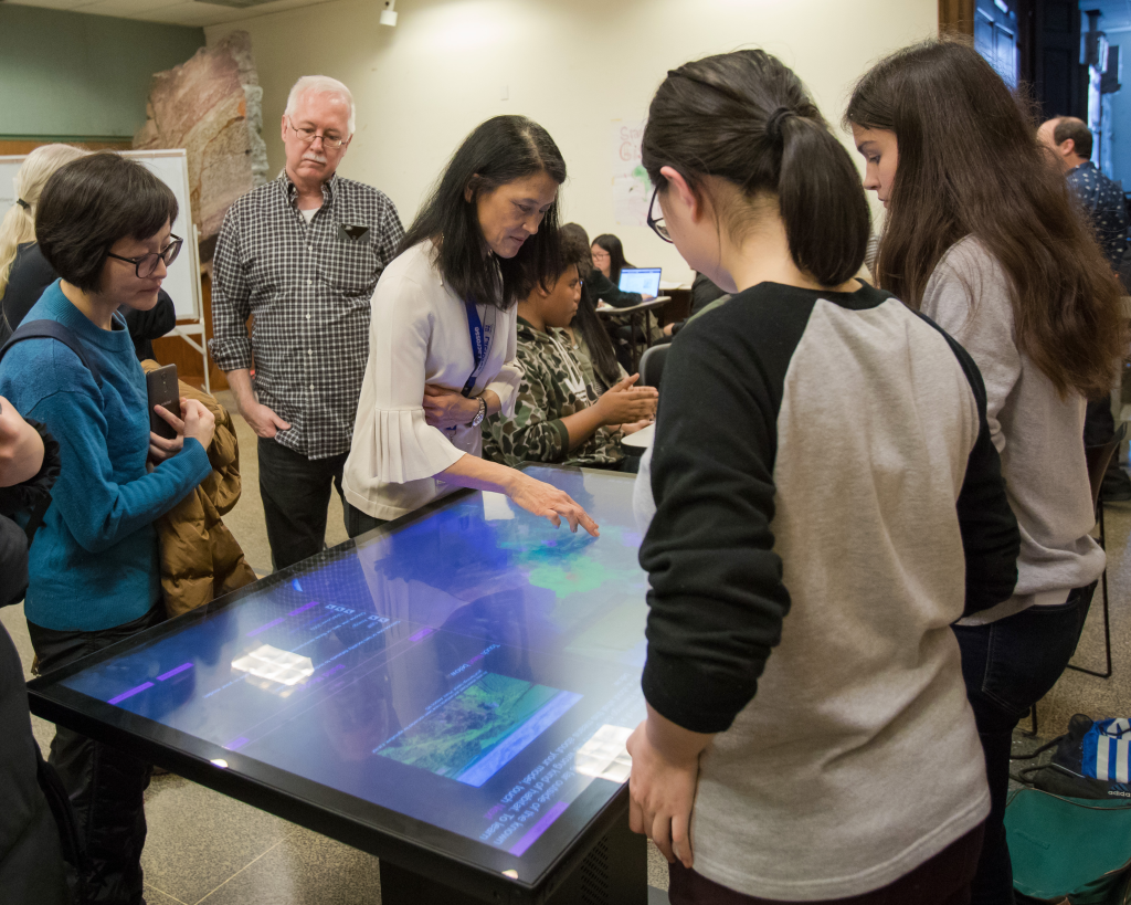 A group of visitors using a digital touchtable