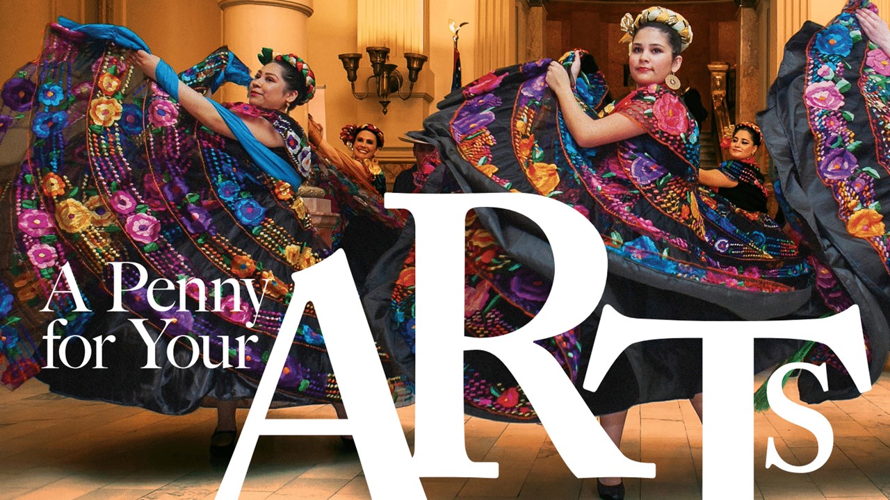 Three dancers wearing colorful large skirted dresses spin in the interior courtyard of a museum.