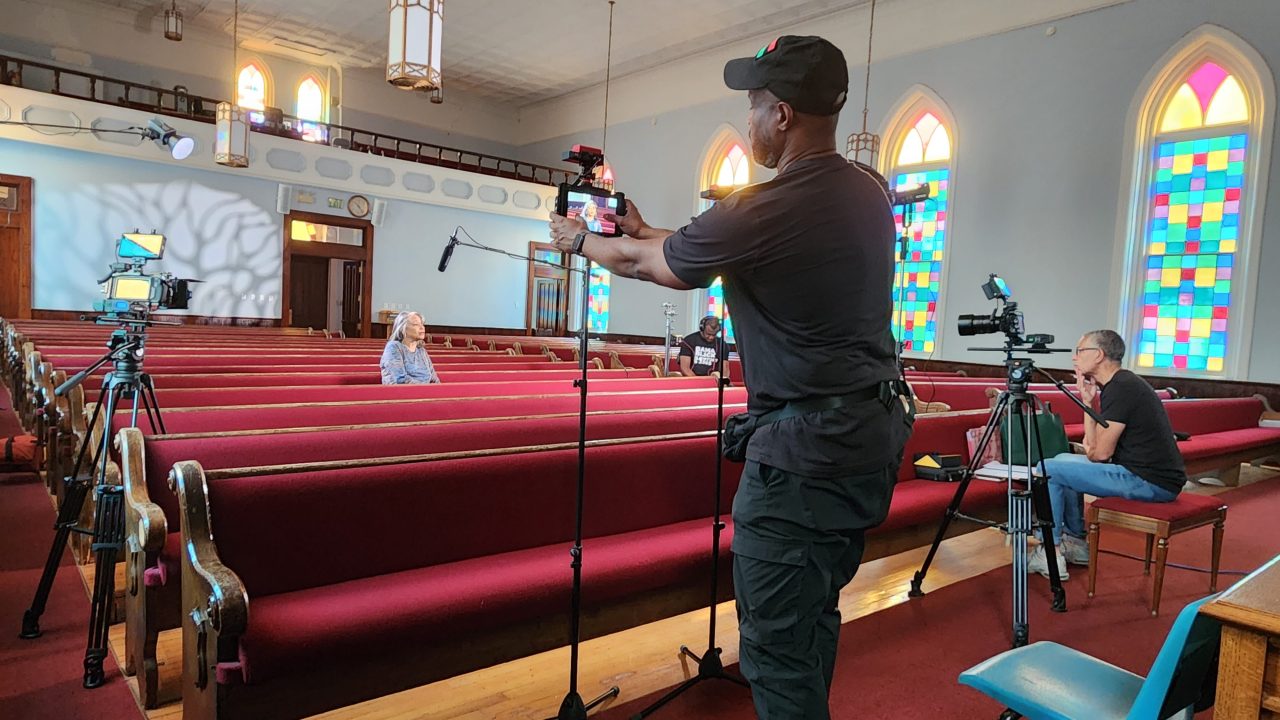 A camera crew set up to interview a subject in a church