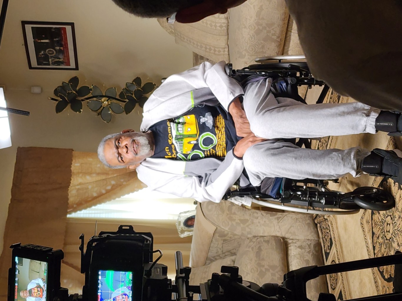 An interview subject seating in a wheelchair wearing a t-shirt commemorating the sixtieth anniversary of the Montgomery bus boycott