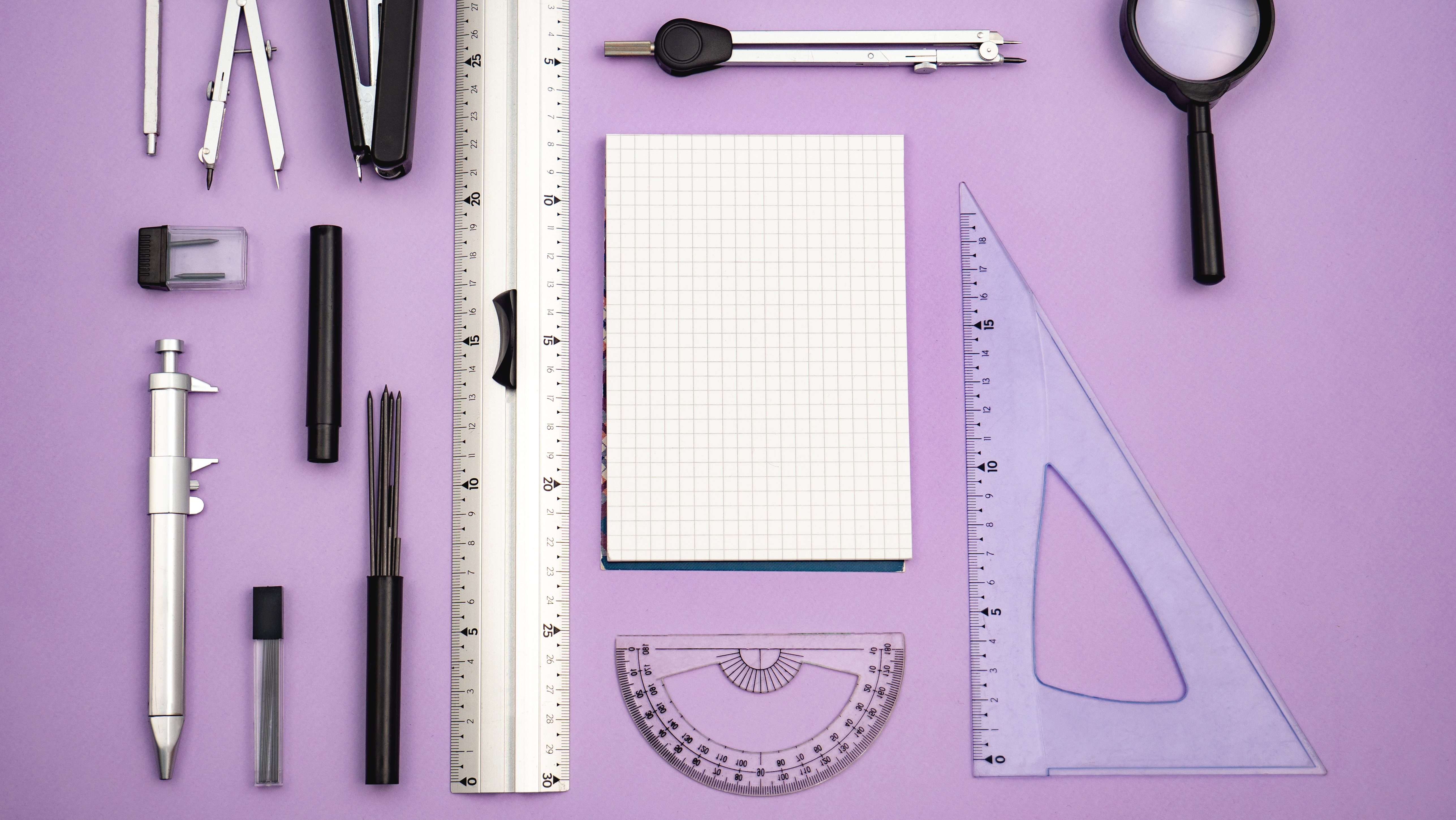 An array of measuring tools laid out on a purple background