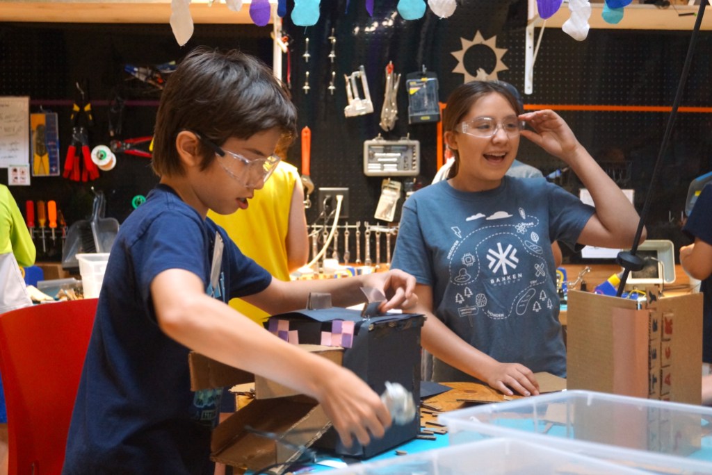 Two children working on diorama projects in a classroom setting