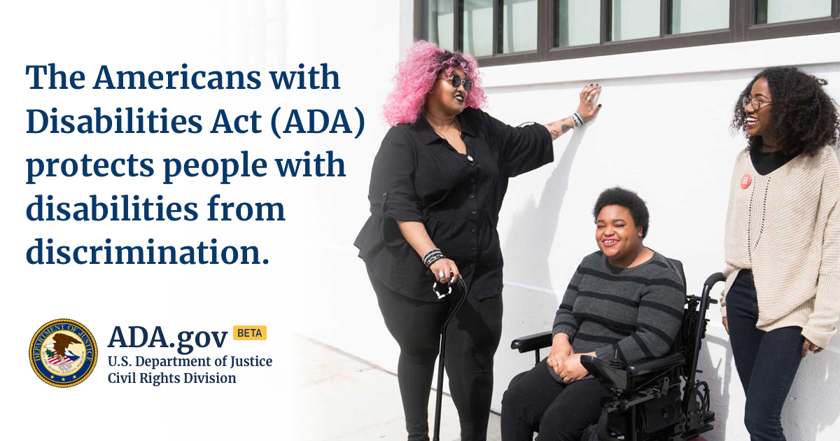 A group of three people with varying disabilities stand or sit outside an office building.