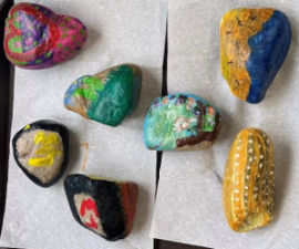Painted rocks on top of paper.