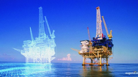 A oil rig sits in the open ocean with a digital double outlined in white to the left of the physical rig.