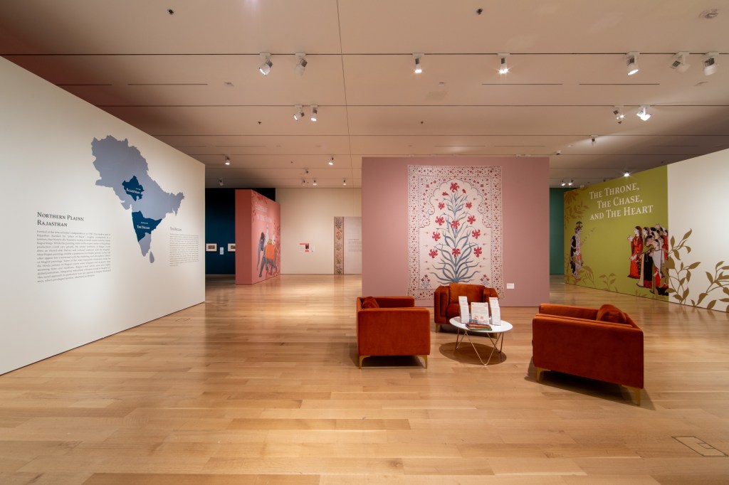 A large museum exhibit room, featuring a large wall map and group seating.