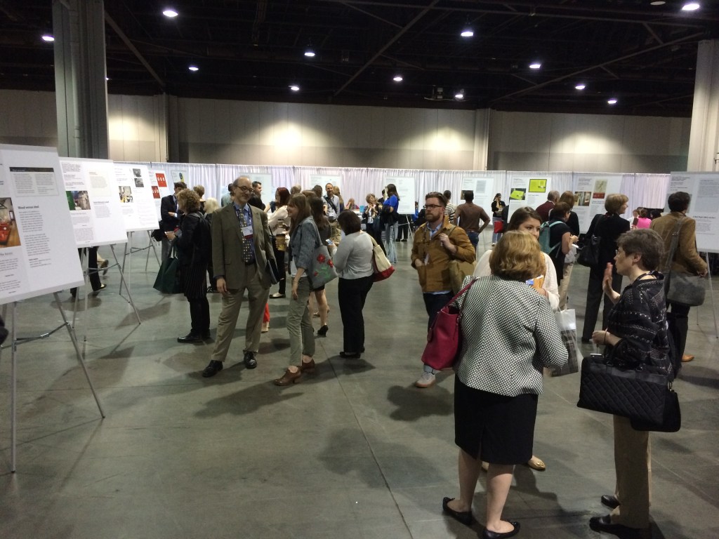A group of people gathered at the annual meeting, surrounded by various posters.