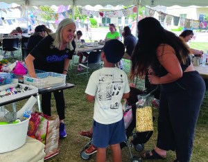 Patty Bode welcomes a family into the art-making tent at the John Michael Kohler Arts Center’s 2023 Midsummer Festival of the Arts and introduces the Remember Love Recovery Project.