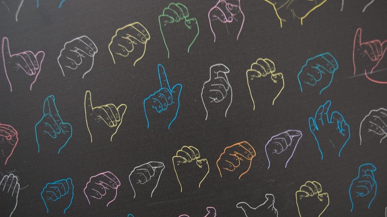 Line drawings of American Sign Language gestures in an array of different colors