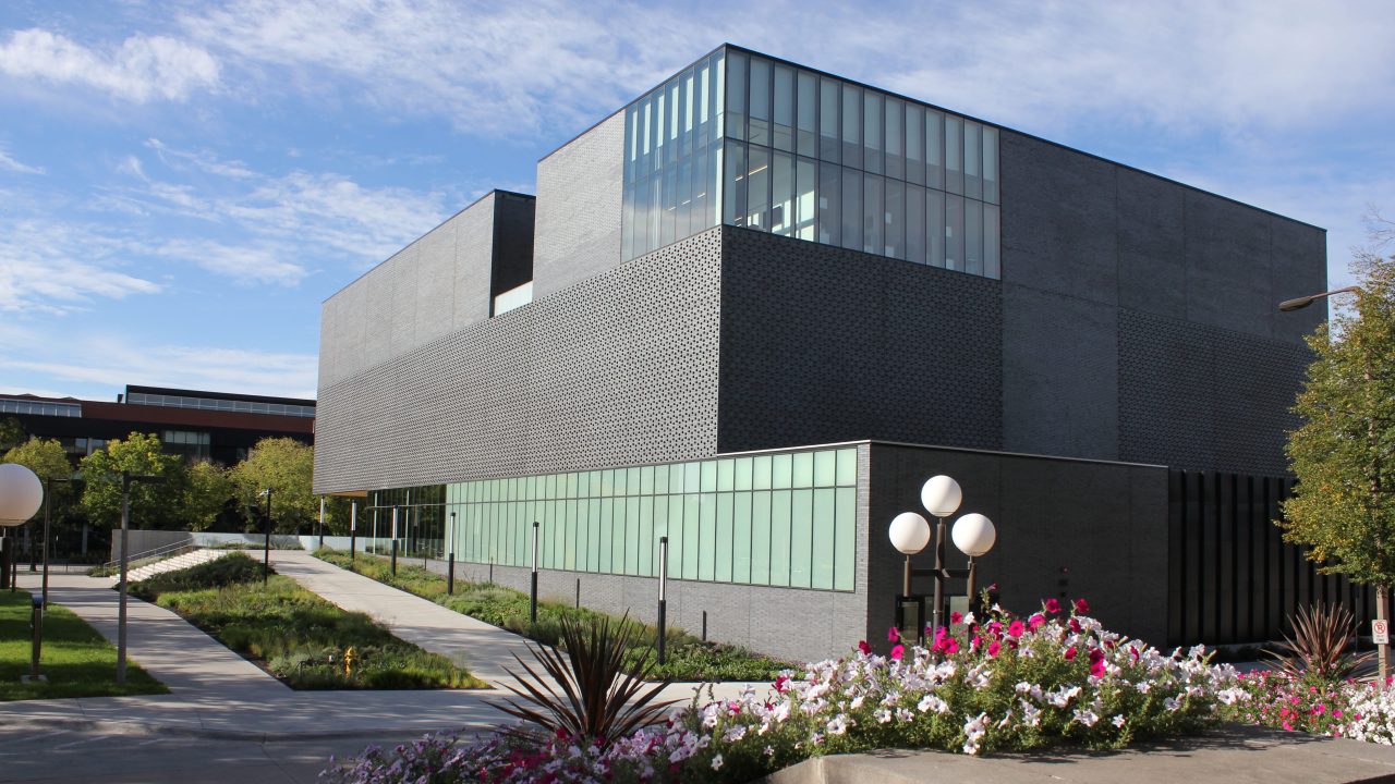 A two-level dark grey modern museum building exterior
