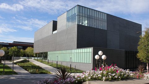 A two-level dark grey modern museum building exterior