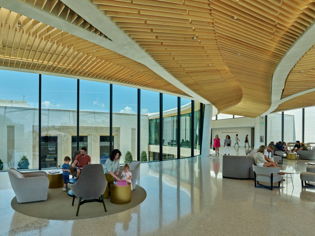 People sitting and walking in Arkansas Museum of Fine Arts' Cultural Living Room.