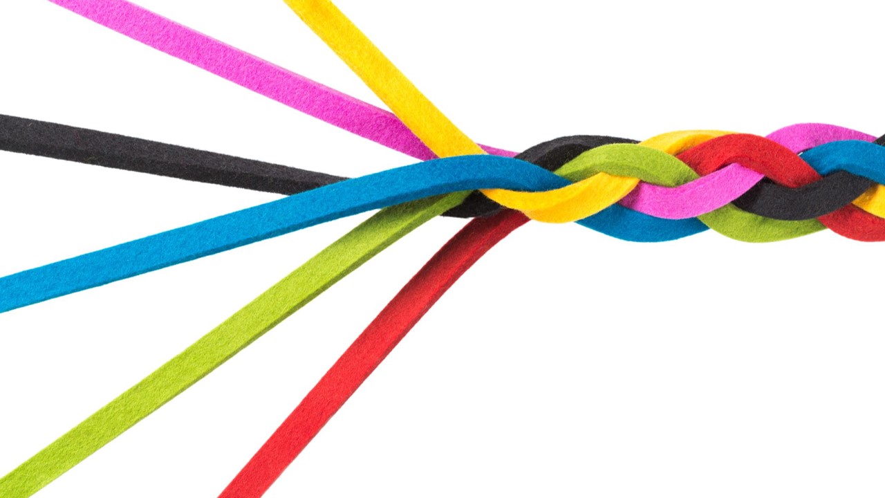 Strands of multicolored string braided together on one end and loose at the other.