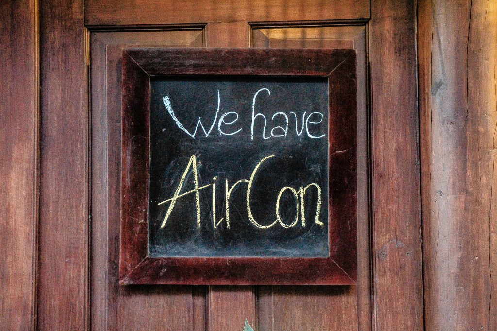 A chalkboard sign reading "We have AirCon."