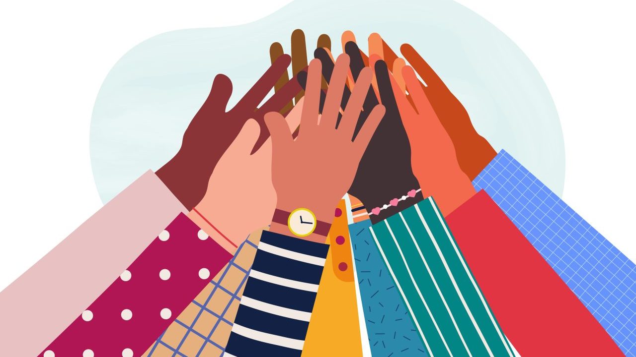 Hands of a group of people together raised up.