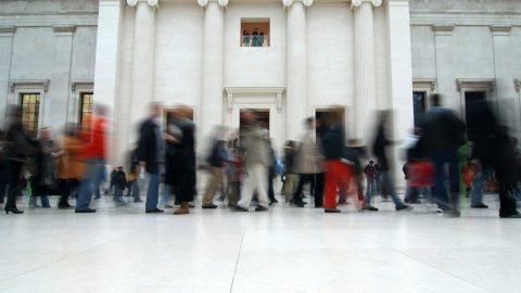 A bunch of museum visitors walking around a museum hall