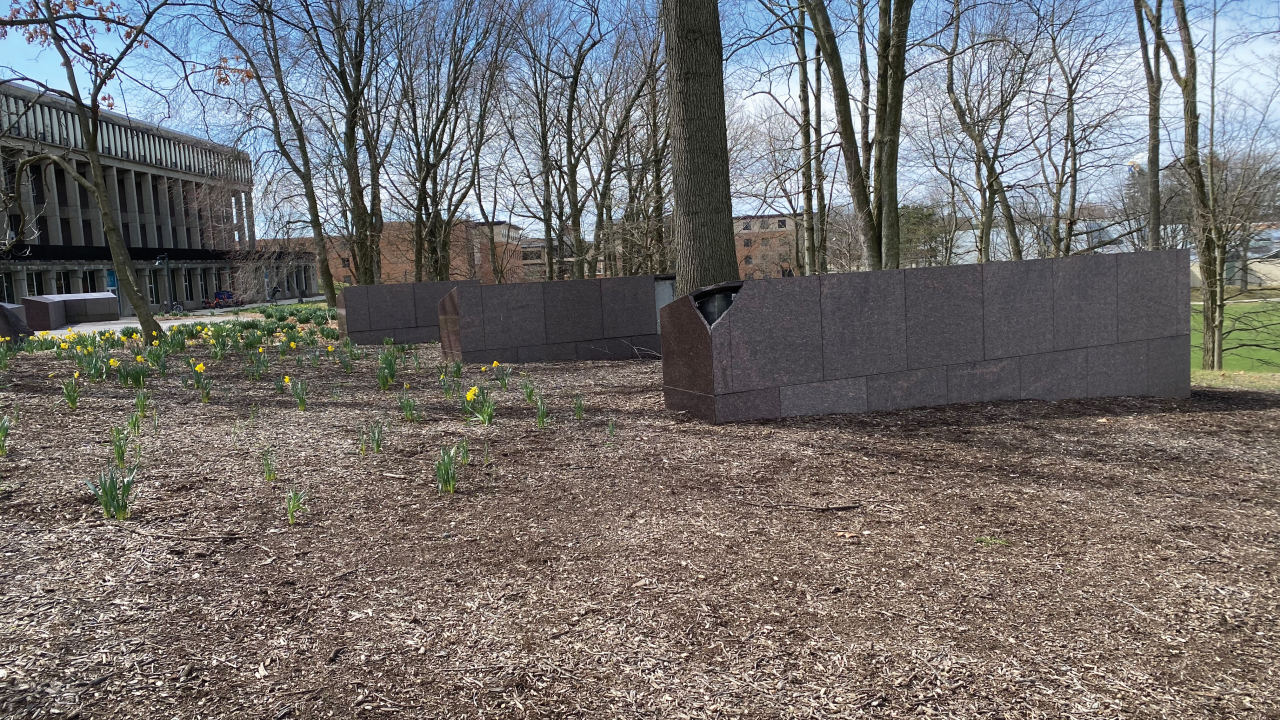 An outdoor memorial featuring two horizontal pillars in between trees
