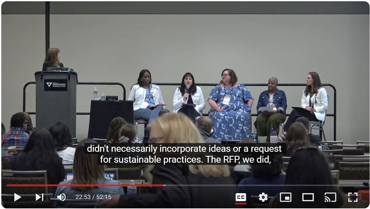 A group of six women sit and stand on a stage during a session at the Annual Meeting.