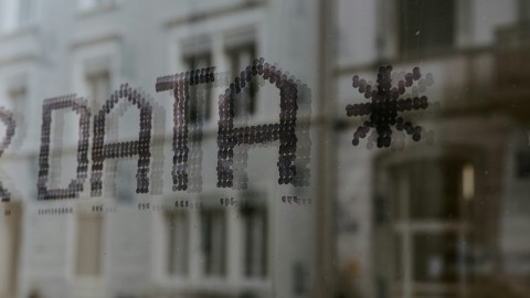 A glass facade with the word "data" projected on it