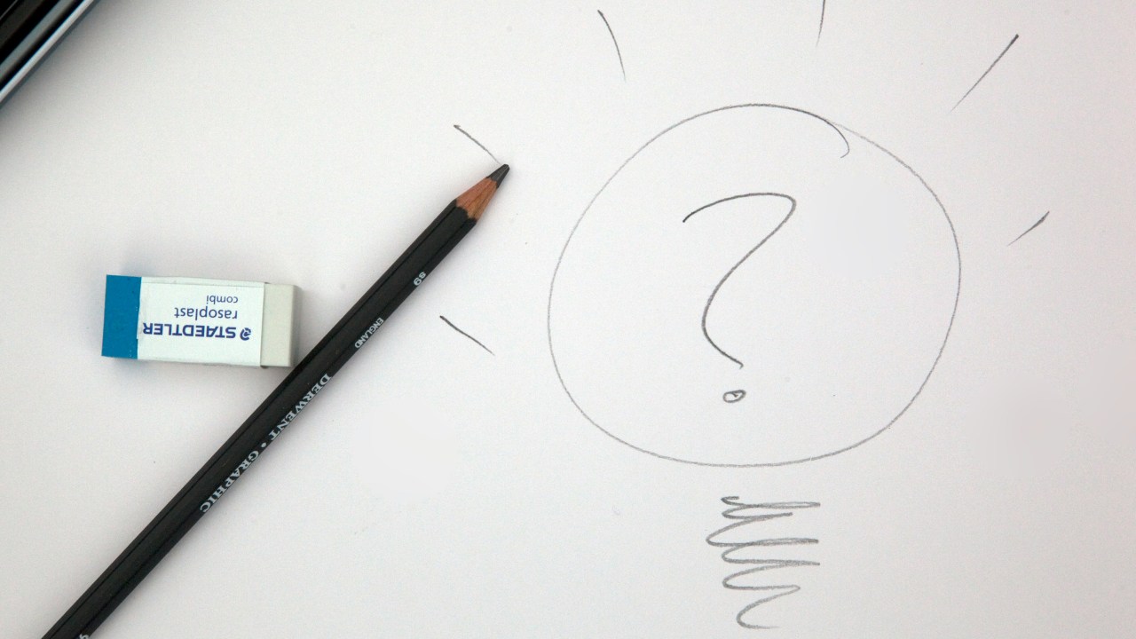 A drawing of a lightbulb with a question mark inside of it on a whiteboard
