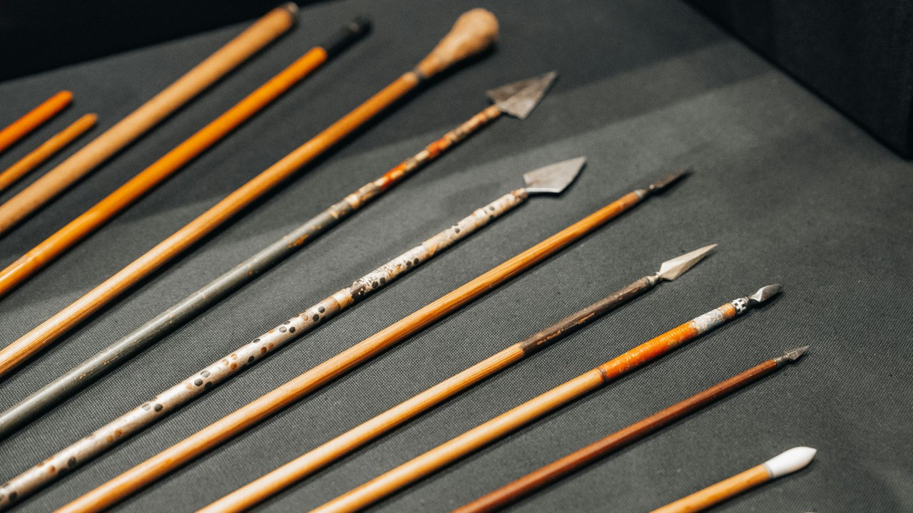 A series of arrows lined up on a dark colored background.