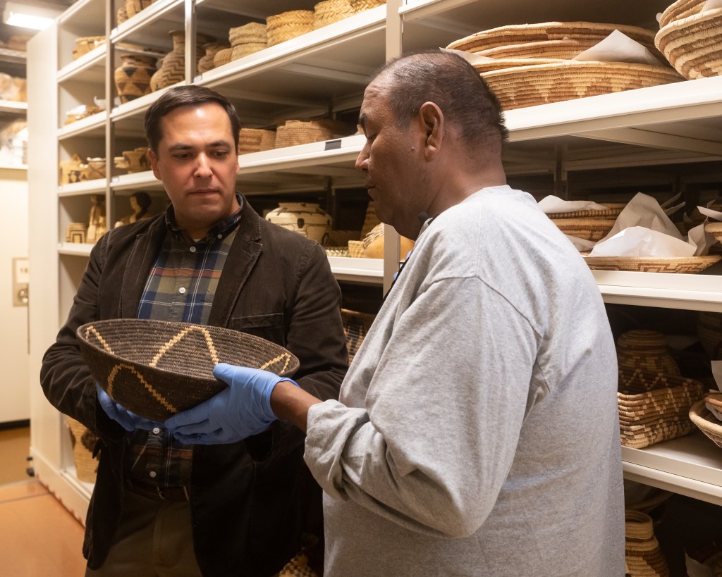 Terrol Dew Johnson, Tohono O’odham basketmaker, is recorded choosing objects with ASM associate curator Ed Jolie in Arizona State Museum’s vault, photograph by Max Mijn, ASM.