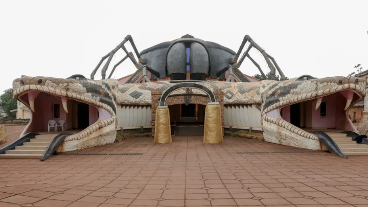 A frontal view of a building whose entrance resembles a snake