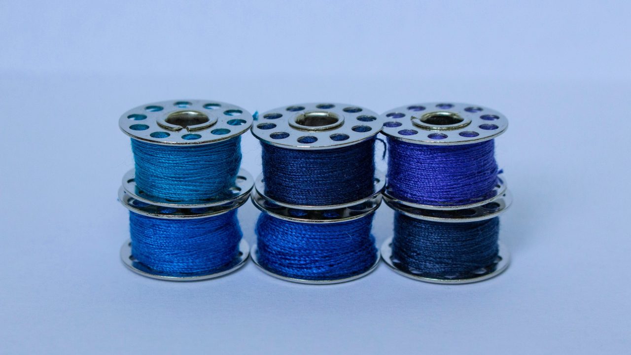A set of six spools of blue thread
