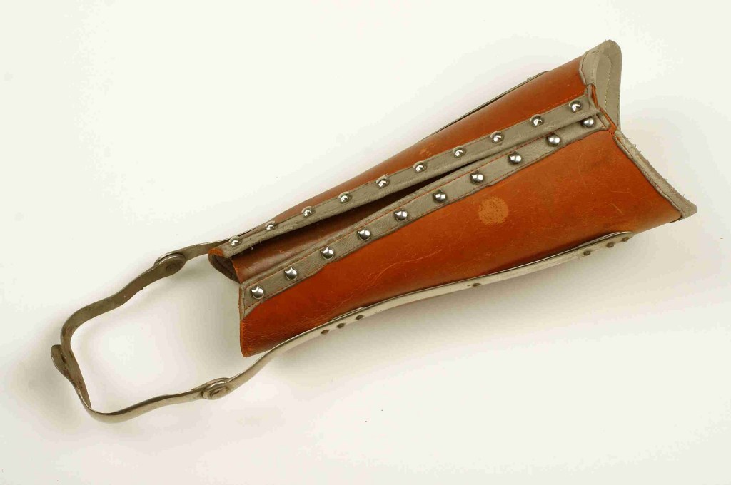 Leather contraption with metal trim and an ankle strap. 