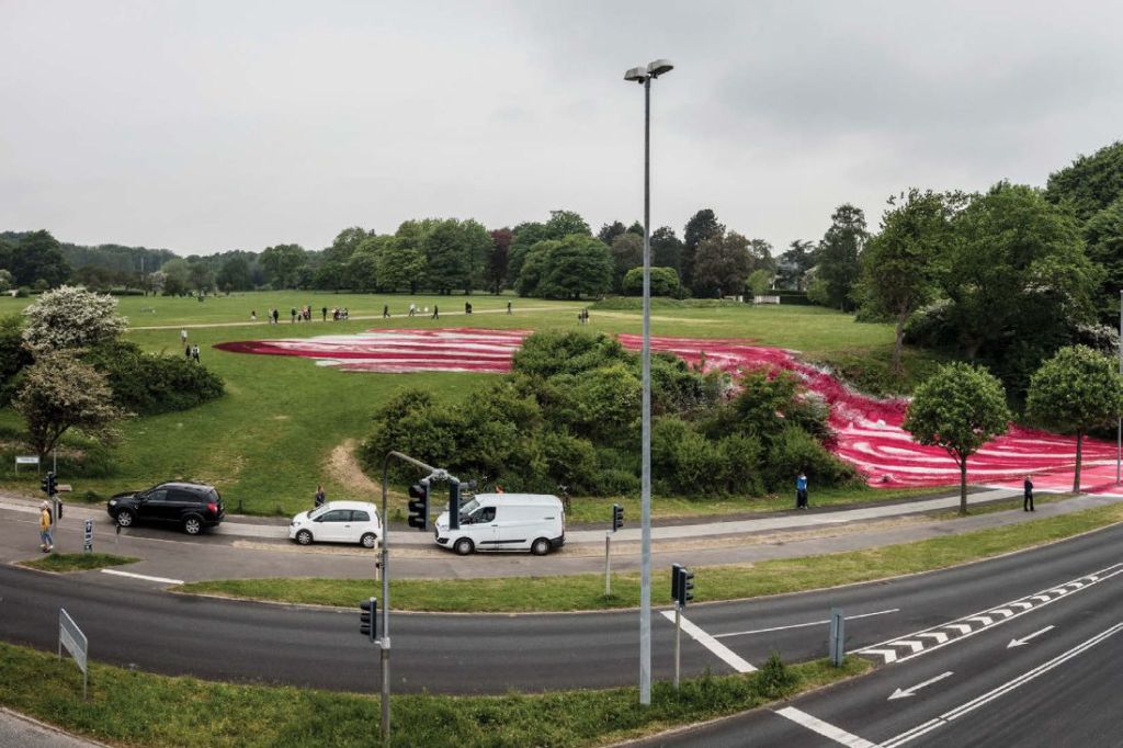 View of the exterior of the museum grounds with a road and the art installation crossing the road.