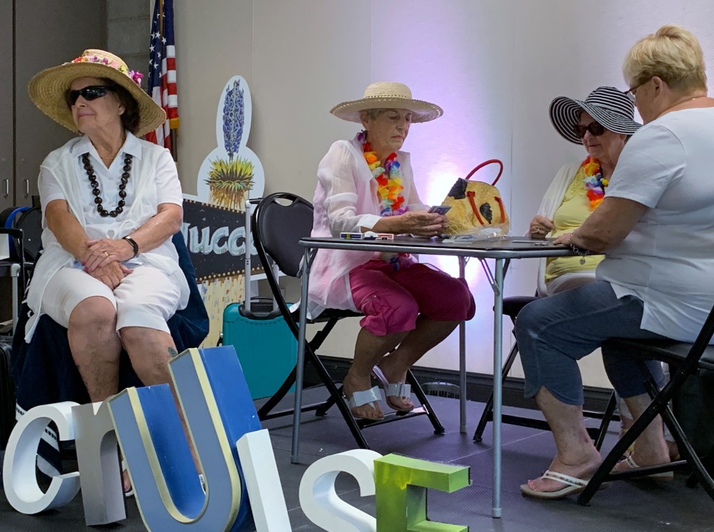 A group of participants on stage sitting at a table in their scene