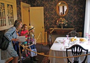 Image of a family of two children viewing the dining room at the Pittock Mansion.