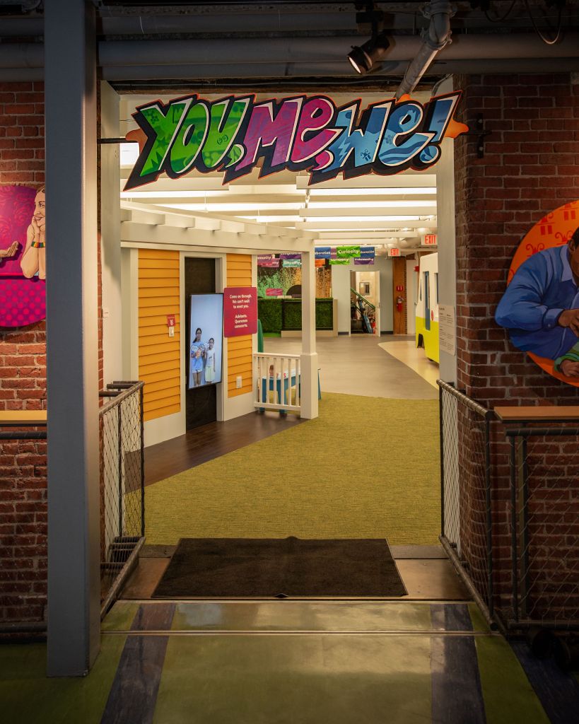 A sign displaying the words "you me me" at the entrance of a exhibit