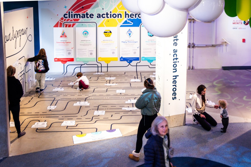 People standing in front and around a climate action display