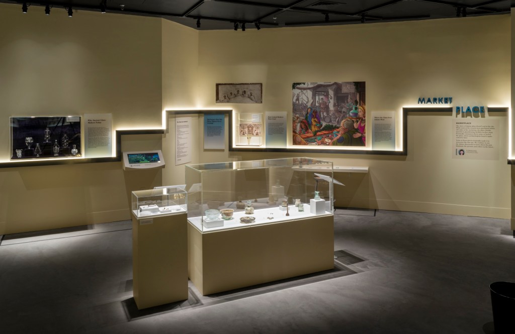 A room in the exhibition with cased objects in the center and a timeline on the wall behind.