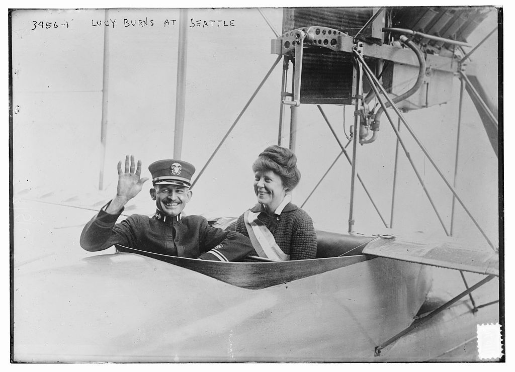 Lucy burns smiling in the cockpit of a small plane.