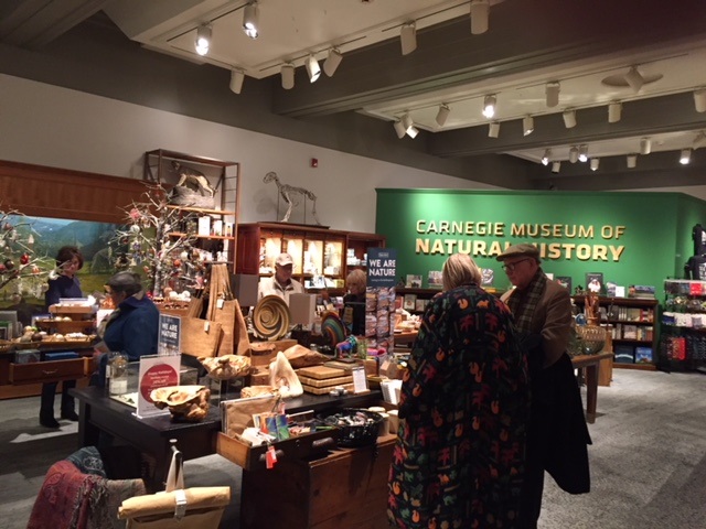 Interior view of the Carnegie Museum of Natural History's Museum store with a few people shopping. 