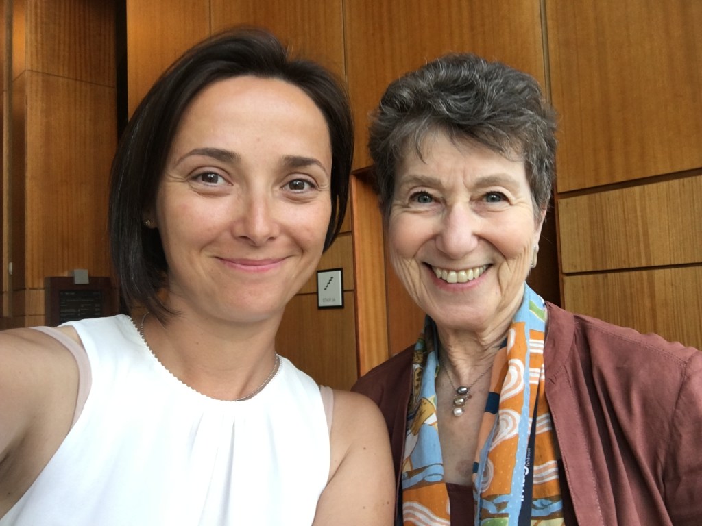 Two women standing close to each other taking a selfie. 