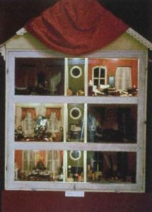 A three story dollhouse with six rooms and a central small area on each level. 