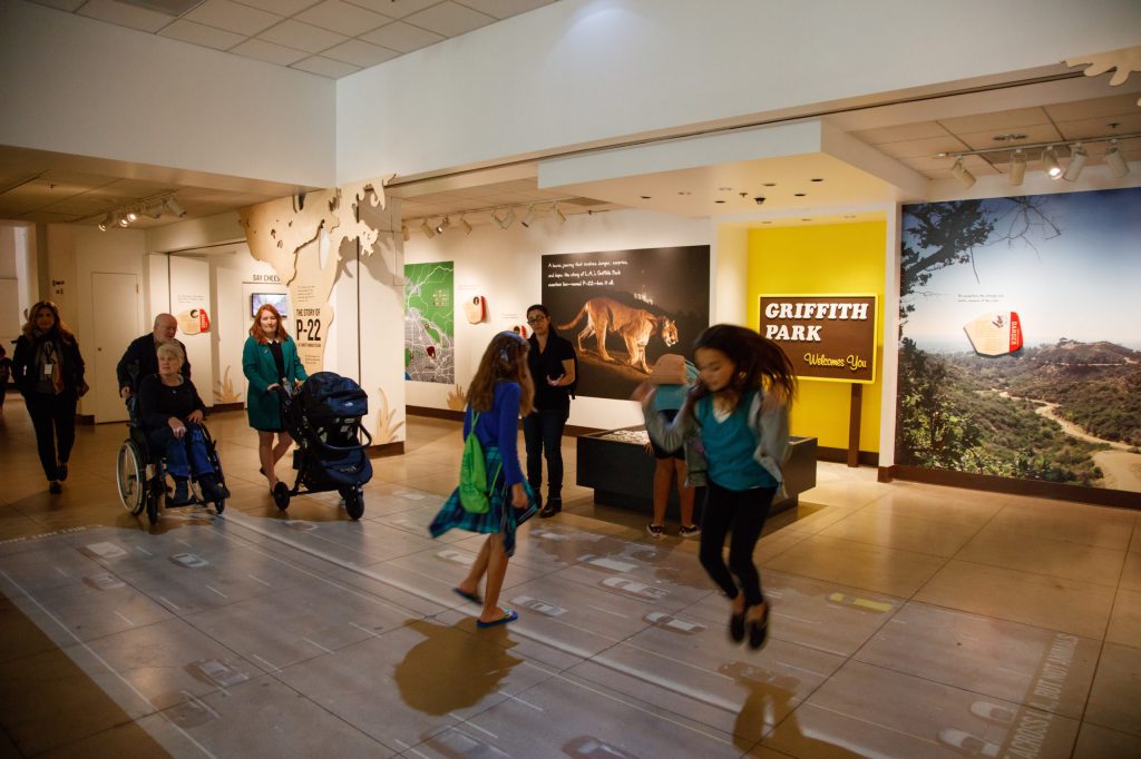 Children walking over a projection of freeway traffic on the floor