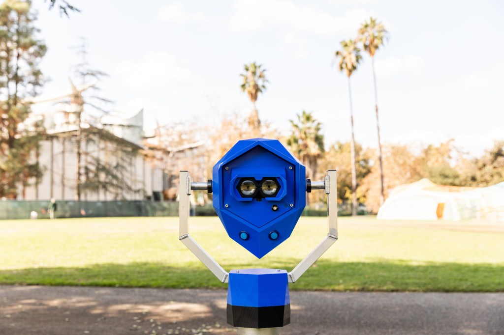 A blue device resembling a periscope, with illustrations of eyes over the eye holes
