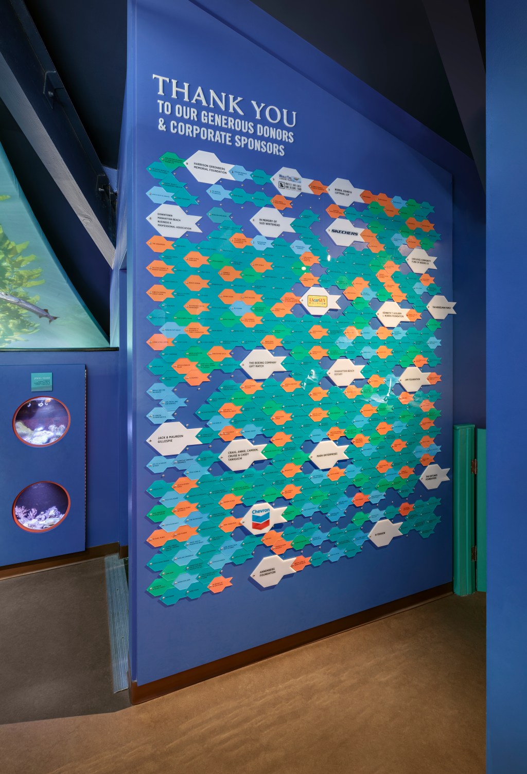 Designers at CambridgeSeven used the principle of "design for deconstruction" for this donor panel recognition wall at the Roundhouse Aquarium in Manhattan Beach. They selected a security screw that works well as the eye of the fish. As donors need to be updated, instead of replacing the entire wall, each fish can be printed easily and added or removed as required.