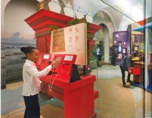 A young girl works with an interactive display in a gallery. 