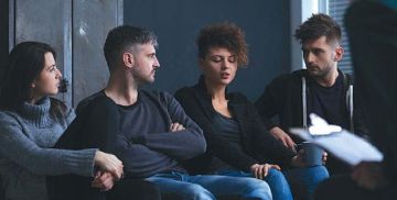 A group of people sit on stage. 