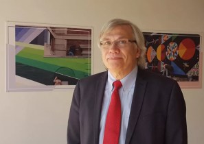 Photo of Carlos Tortolero in front of artwork.