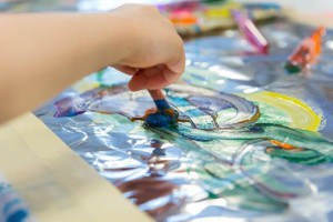 Closeup of a child using a brush with paint