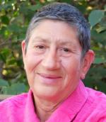 Headshot of Elaine Heuman Gurian with short dark and silver hair wearing a pink shirt. 