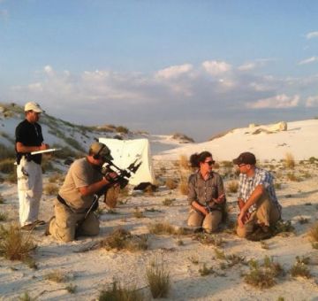 Image of four people in a sandy area. Two of the people are on camera. 