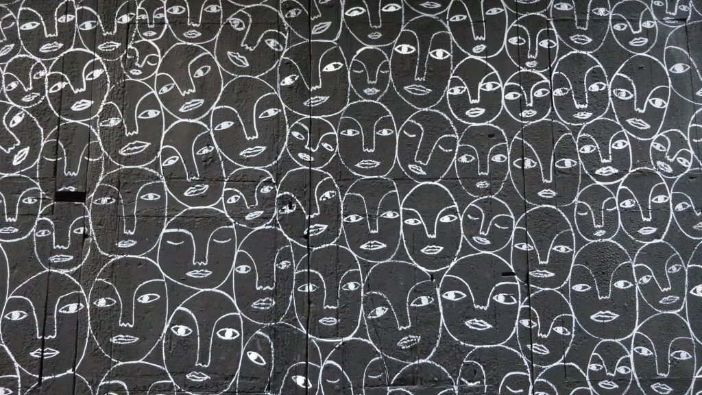 A mural of stylized faces drawn on a wall